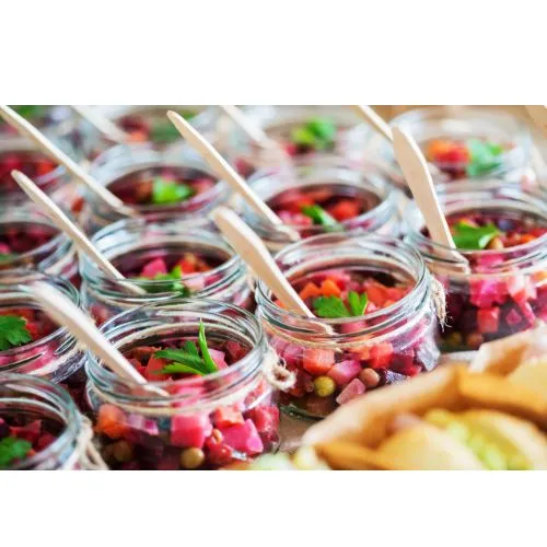 Kleine Gläser mit buntem Rote-Bete-Salat und Holzlöffeln